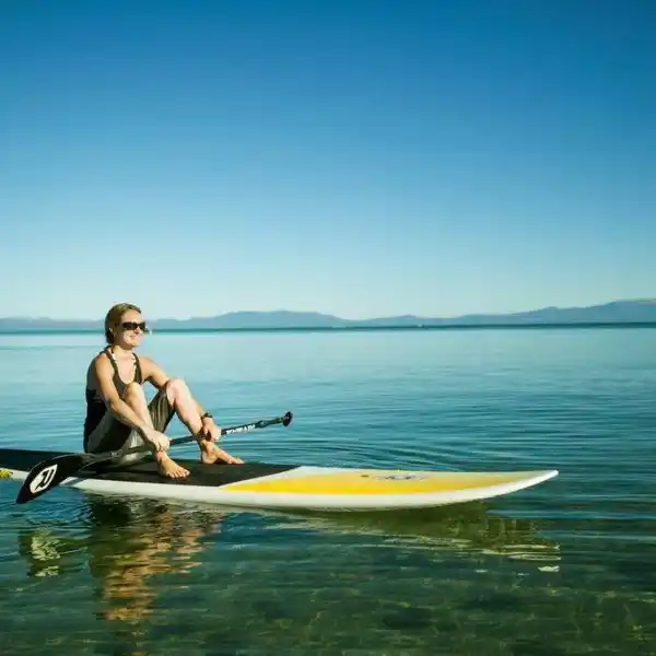 a man riding on the back of a boat in the water