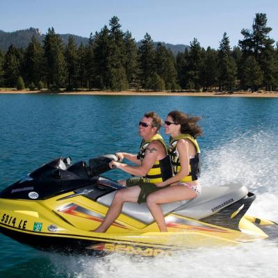 a man riding on the back of a boat in the water