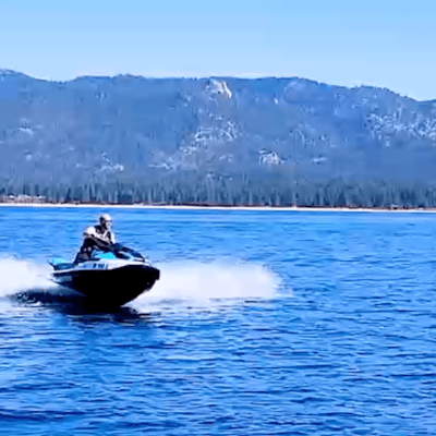 a small boat in a body of water with a mountain in the background